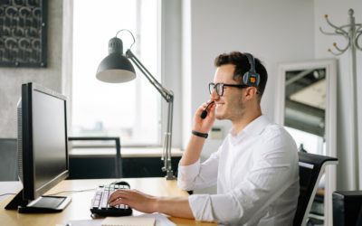 a middle aged man sitting behind a computer helping with IT technologies